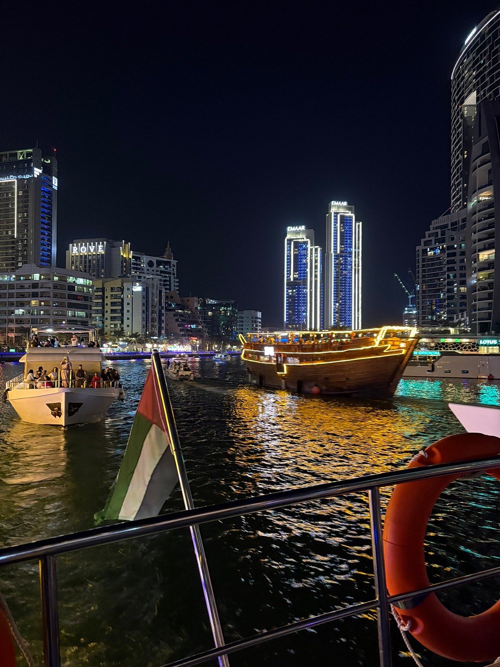 The towers lit from base to roof, reflected on the water
