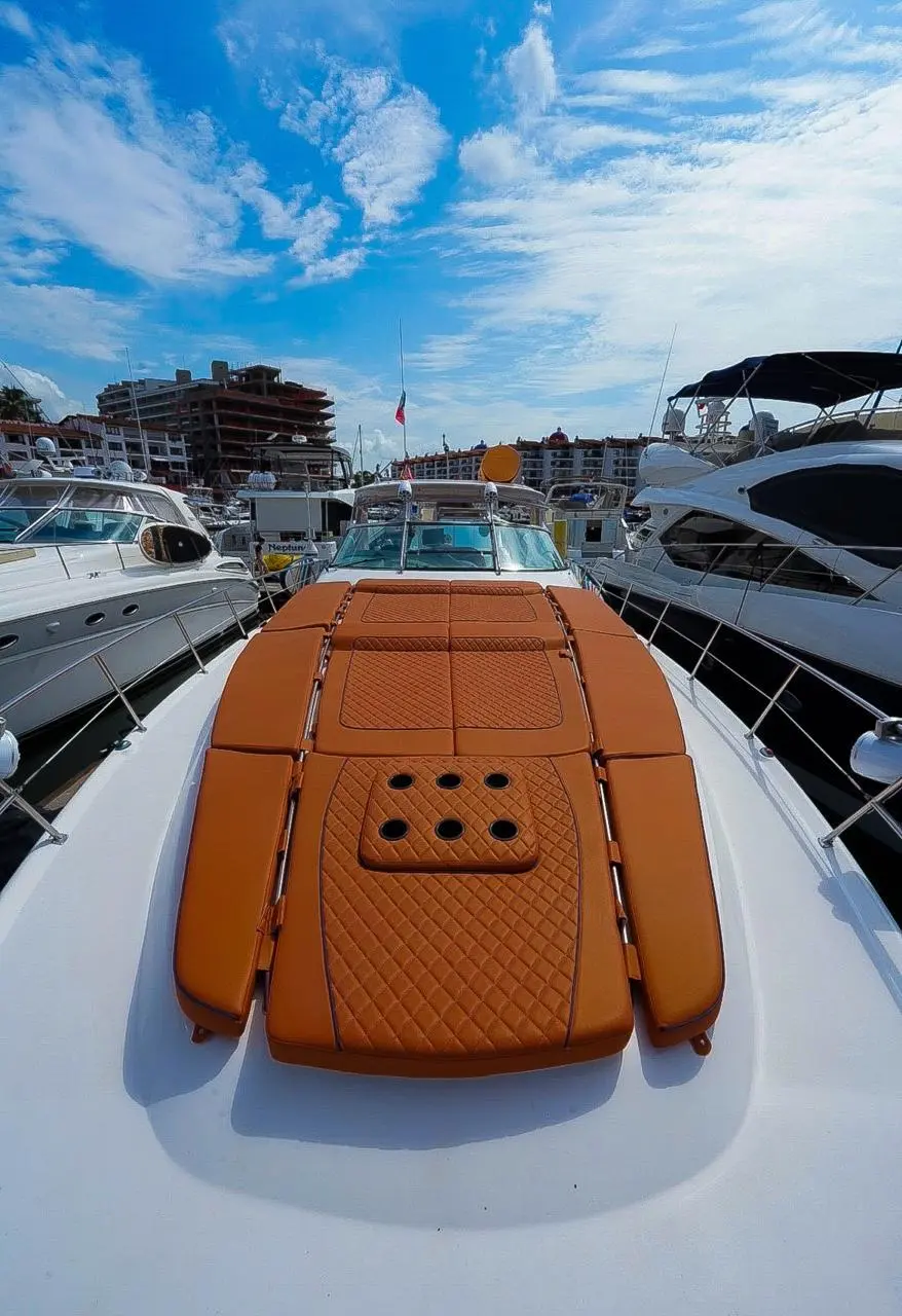 The quilted tan sun pad on the yacht's bow, docked between other boats in a Puerto Vallarta marina