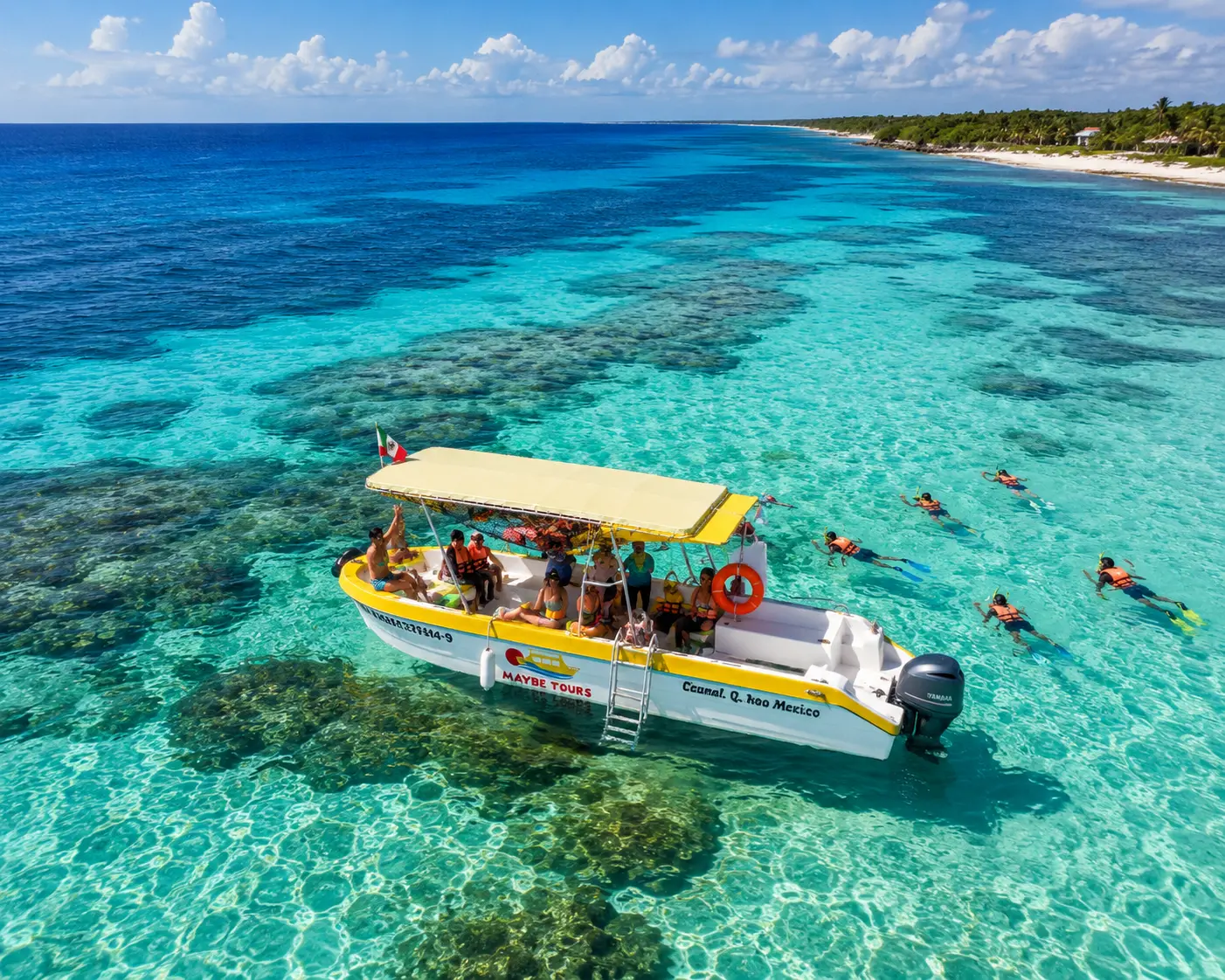 Aerial view of a canopied speedboat anchored over a turquoise reef off Cozumel as snorkelers swim nearby