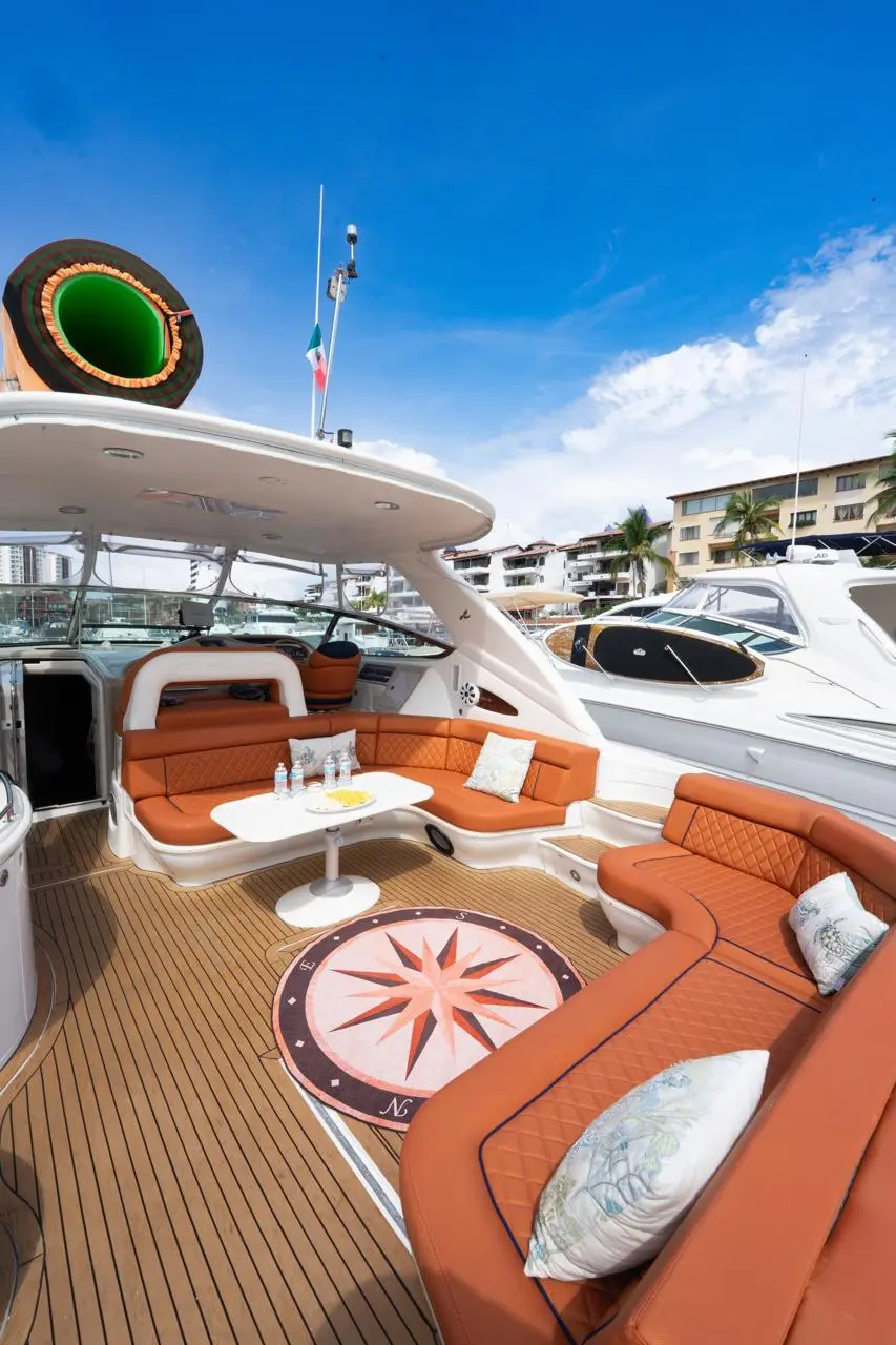 The yacht's cockpit with tan leather lounges around a compass rose inlaid in the teak deck