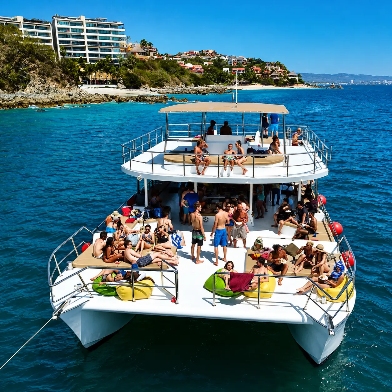 Drone view of the two-deck catamaran with guests sunbathing on its front deck off the Puerto Vallarta coast