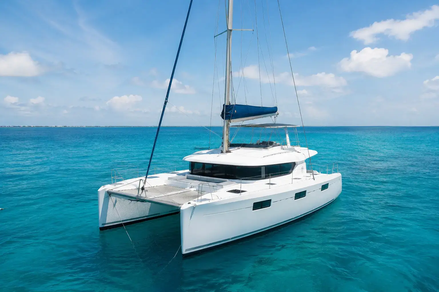Best Catamaran Tours to Isla Mujeres from Cancun for Groups on a luxury catamaran sailing across clear blue Caribbean waters.