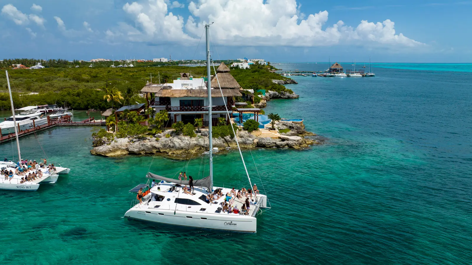 Catamaran with guests anchored by a small island on a catamaran tour from Cancún