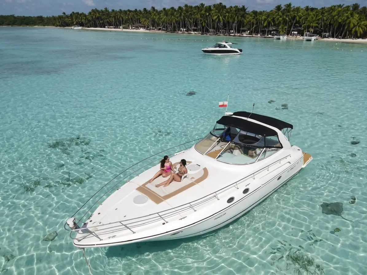 Aerial view of a yacht anchored in clear shallows near Saona Island, two women sunbathing on the bow