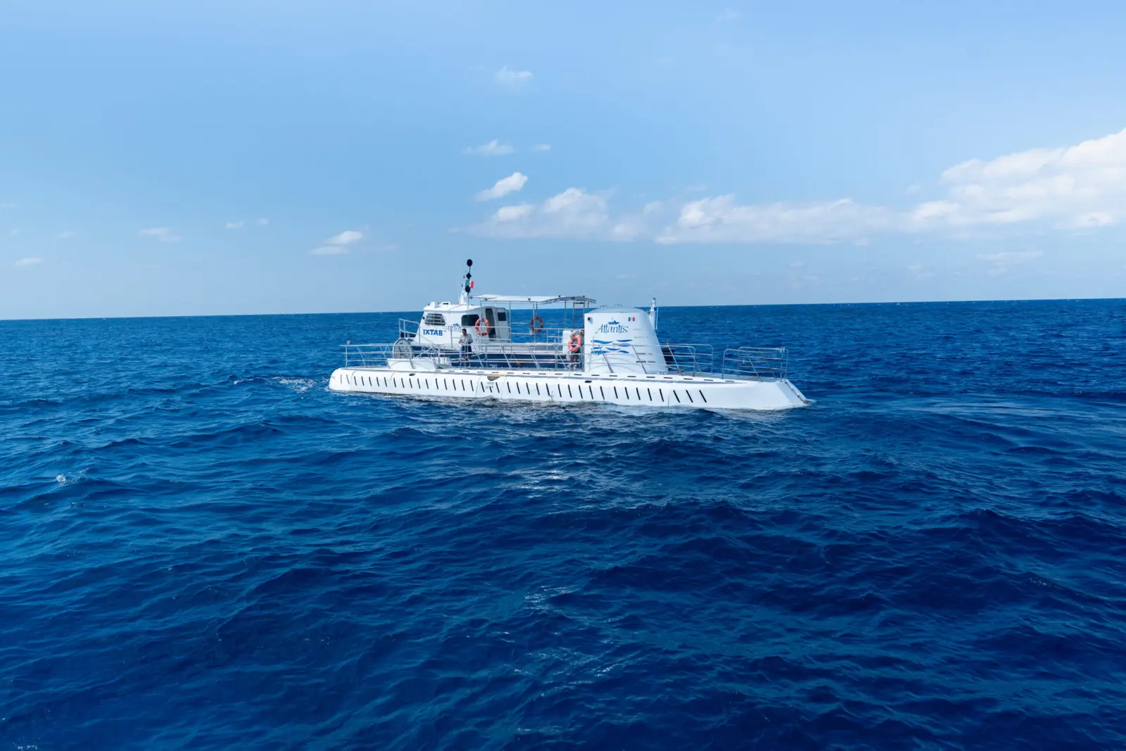 White submarine surfaced on deep blue open water off Cozumel