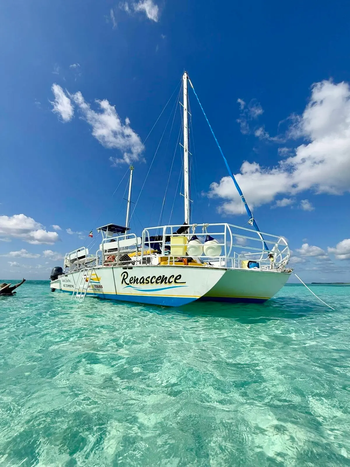 Sailing catamaran at anchor in clear turquoise shallows off Cozumel, seen from water level