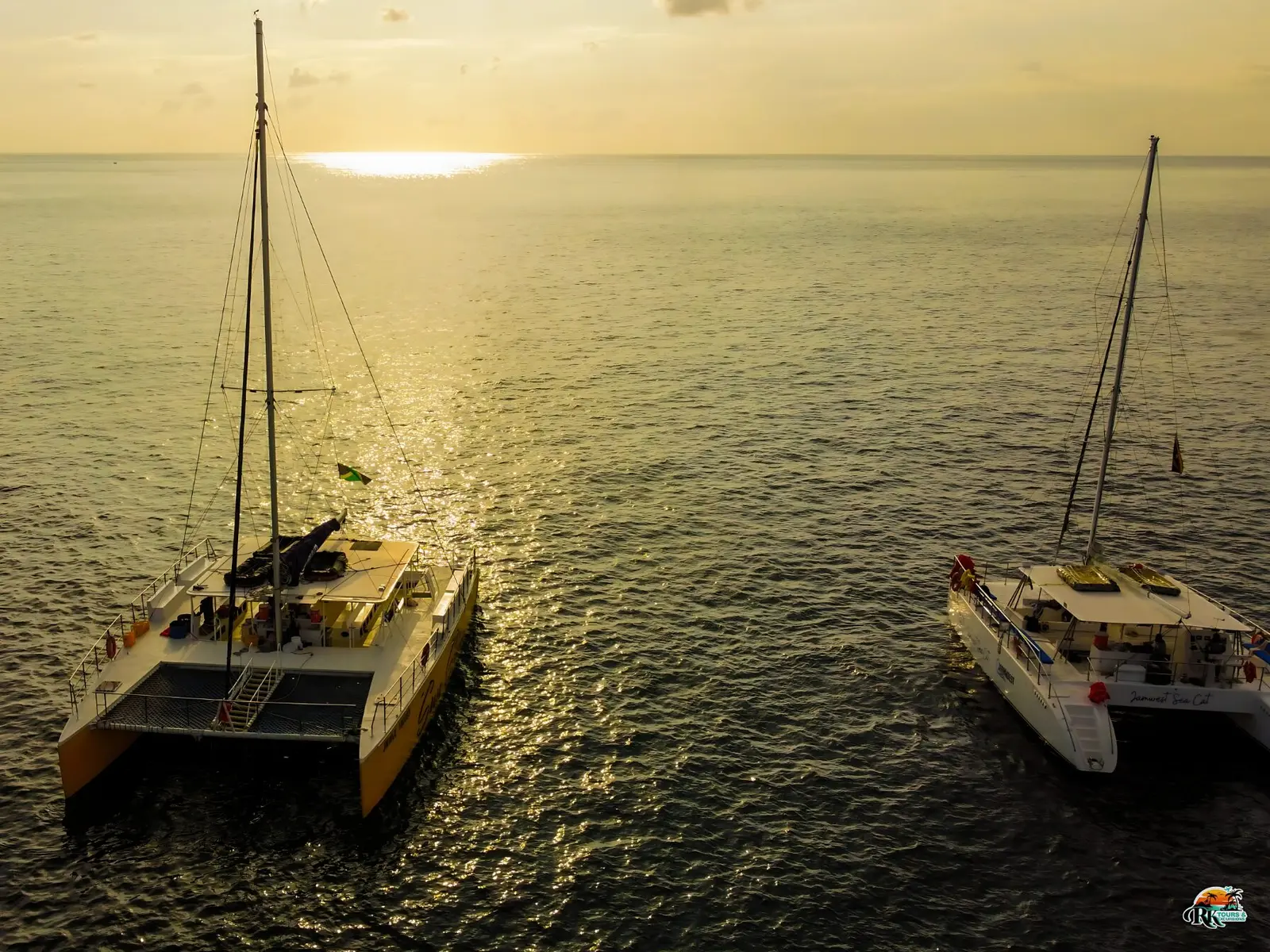 Two sailing catamarans at sunset off Jamaica
