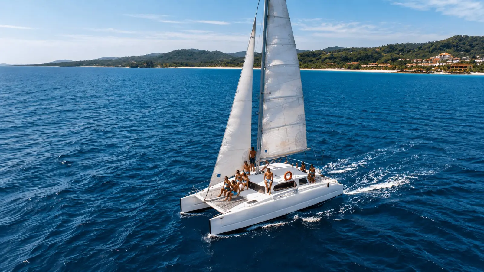 Sailing catamaran with guests under sail off Roatán, Honduras