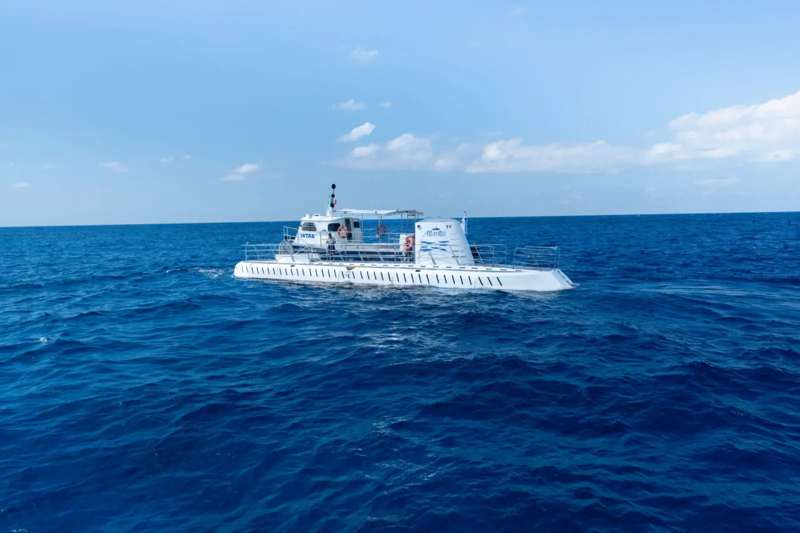 Atlantis submarine tour vessel cruising through deep blue waters off the coast of Cozumel.