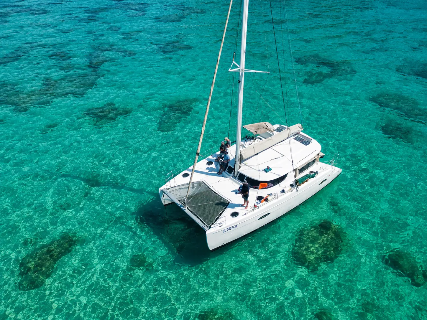 Catamaran anchored over coral reefs in turquoise water off Zanzibar