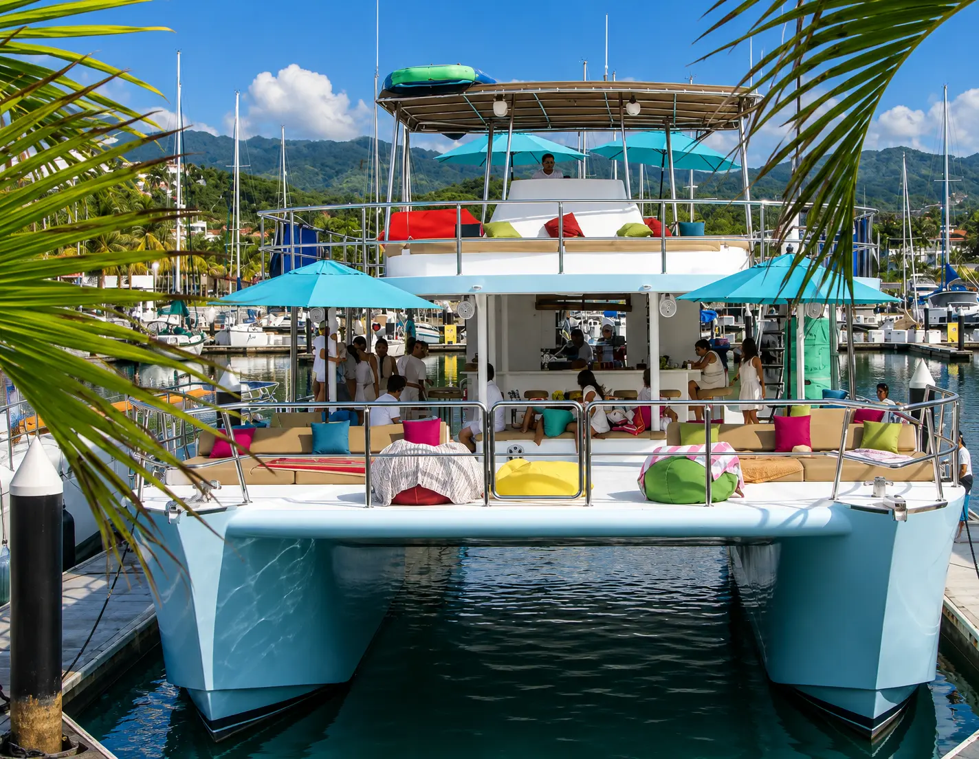 Two-deck catamaran with pale blue hulls moored bow-first in a Puerto Vallarta marina, framed by palm fronds