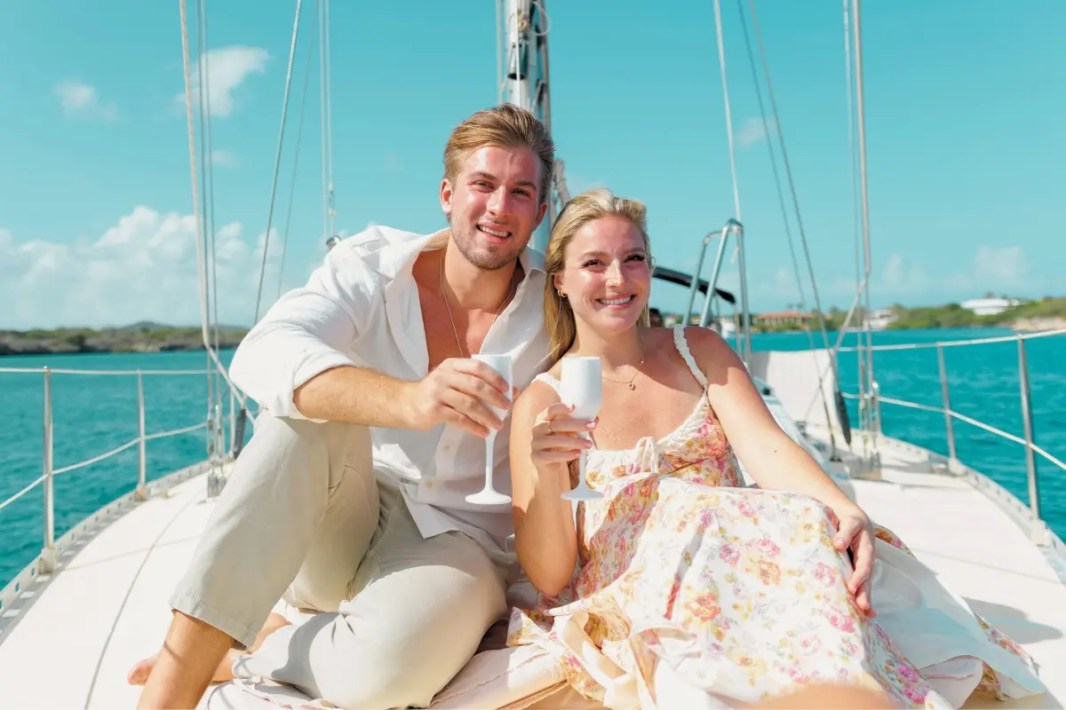 Couple toasting with flutes on the foredeck of a sailing yacht on the Spanish Waters