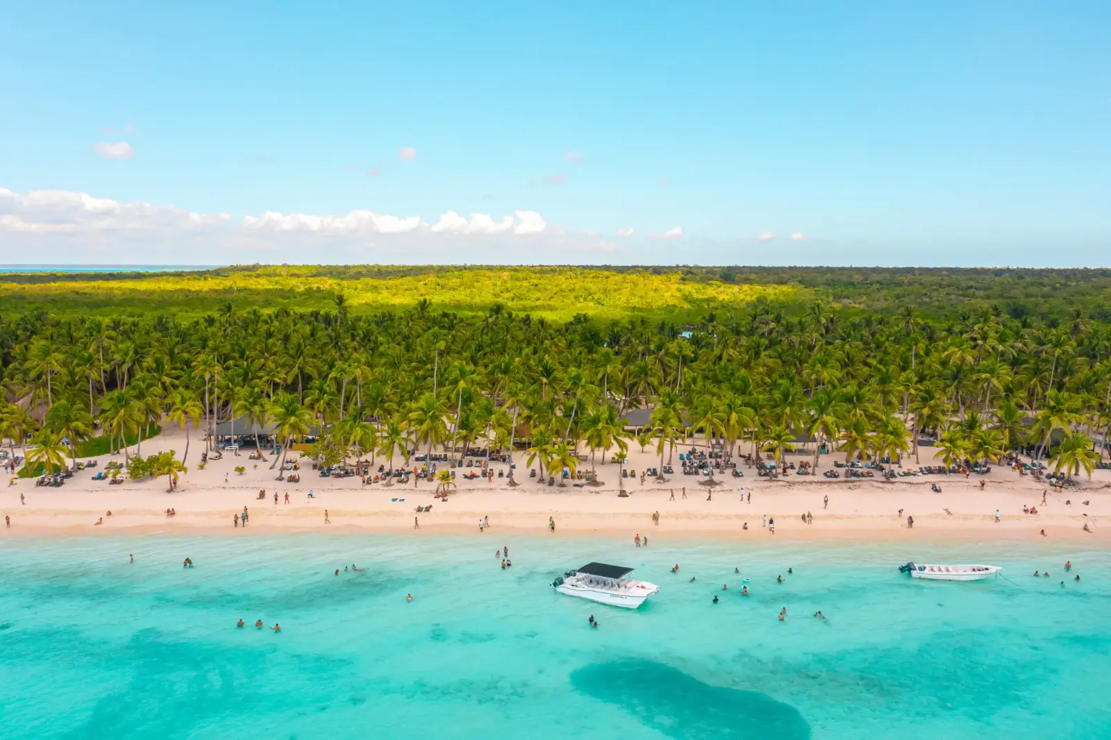 Aerial view of Saona Island's palm-lined beach with boats anchored in turquoise water