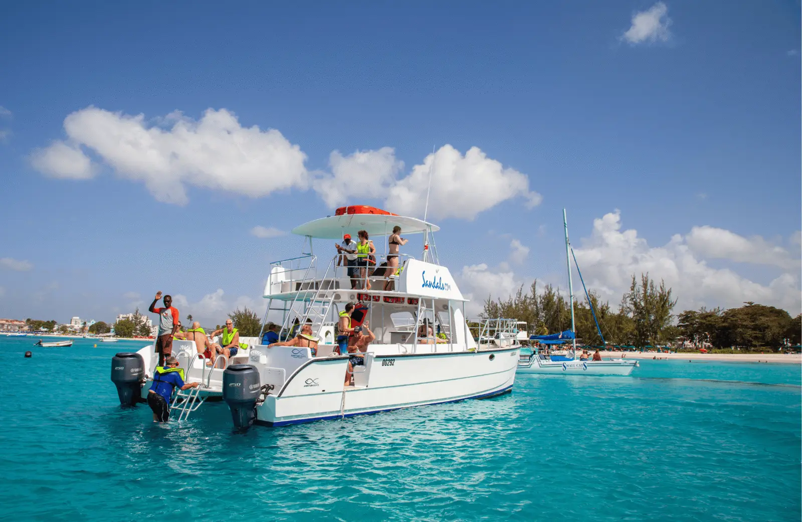 Power catamaran with guests on deck anchored in turquoise water off Catalina Island