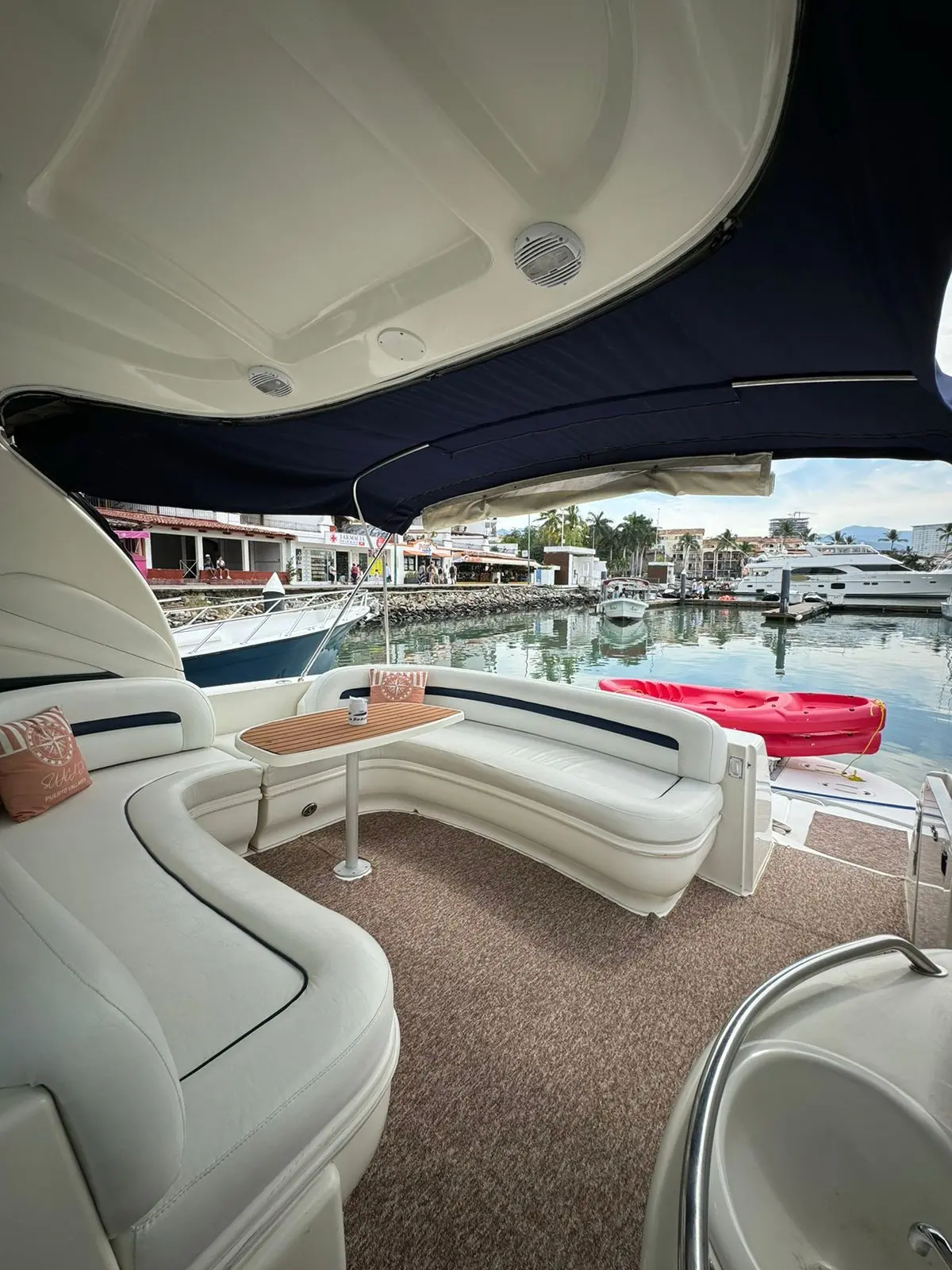 Wraparound cockpit seating and table at the yacht's stern overlooking the marina waterfront