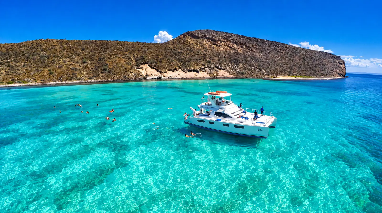 Power catamaran anchored in turquoise water off a desert island near La Paz, Mexico