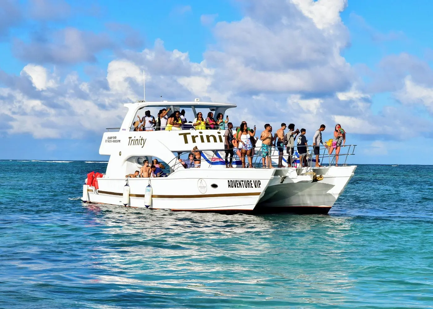 Party catamaran crowded with guests cruising the turquoise sea off Punta Cana