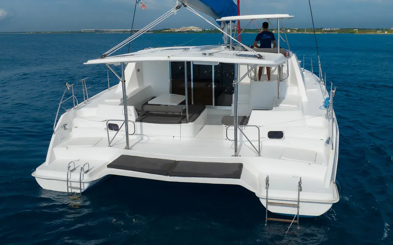 Aerial stern view of a sailing catamaran at anchor on deep blue water off the Riviera Maya