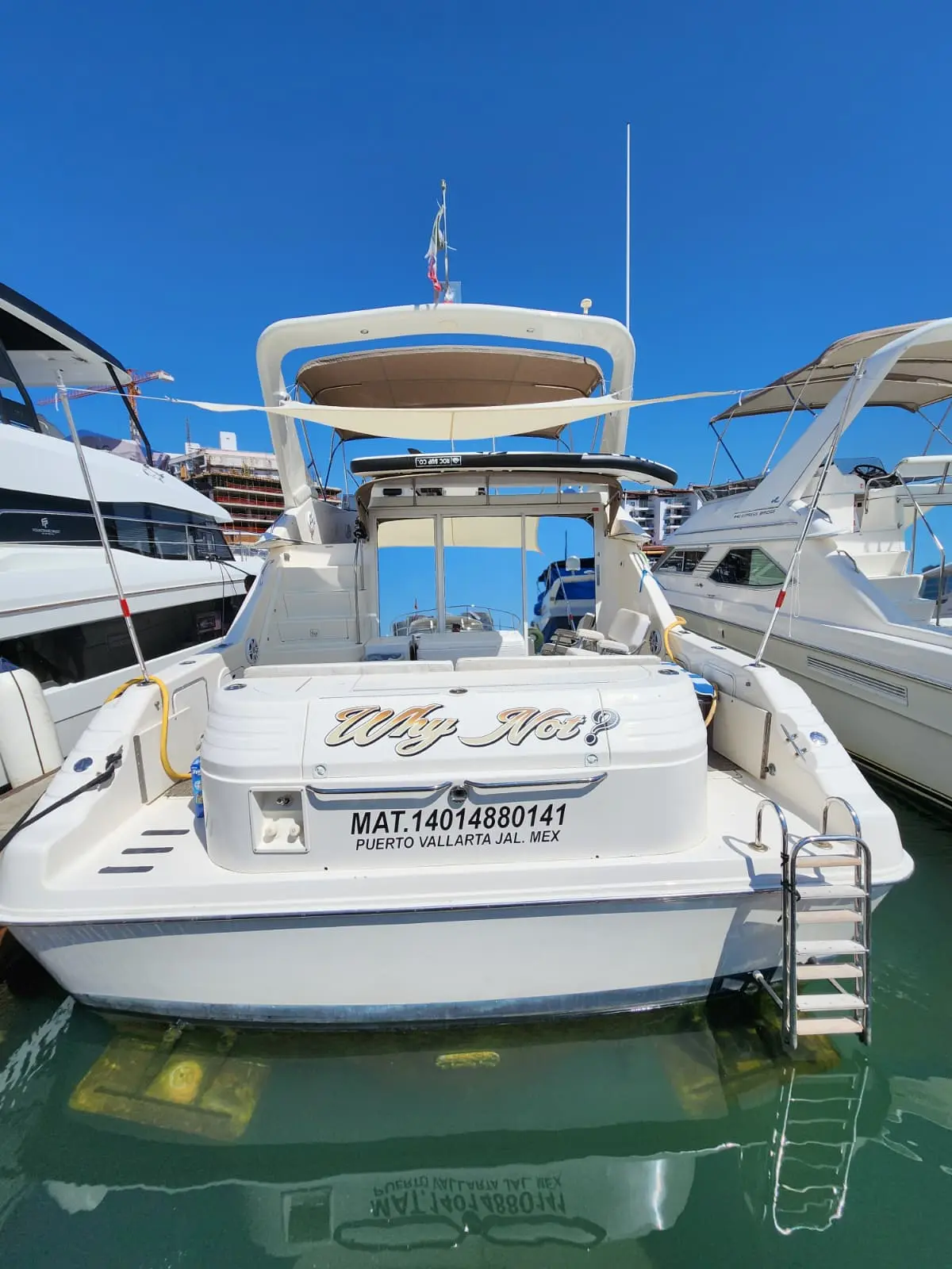 Stern of the motor yacht with swim ladder and flybridge, moored between yachts in the Puerto Vallarta marina